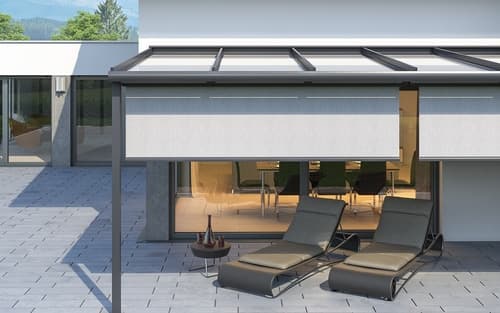 Ausgefahrene Markise über einer möblierten Terrasse an einem Wohnhaus